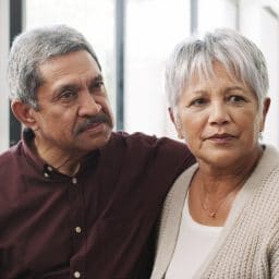 Couple supporting each other at hearing appointment.