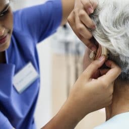 Woman getting her hearing aid adjusted by a professional.