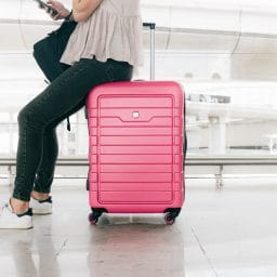 Woman with luggage waiting in an airport.