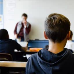 Children listening to a teacher in a classroom environment.