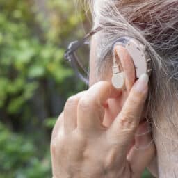 Woman adjusts hearing aid