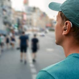 Man with hearing aids stands on street