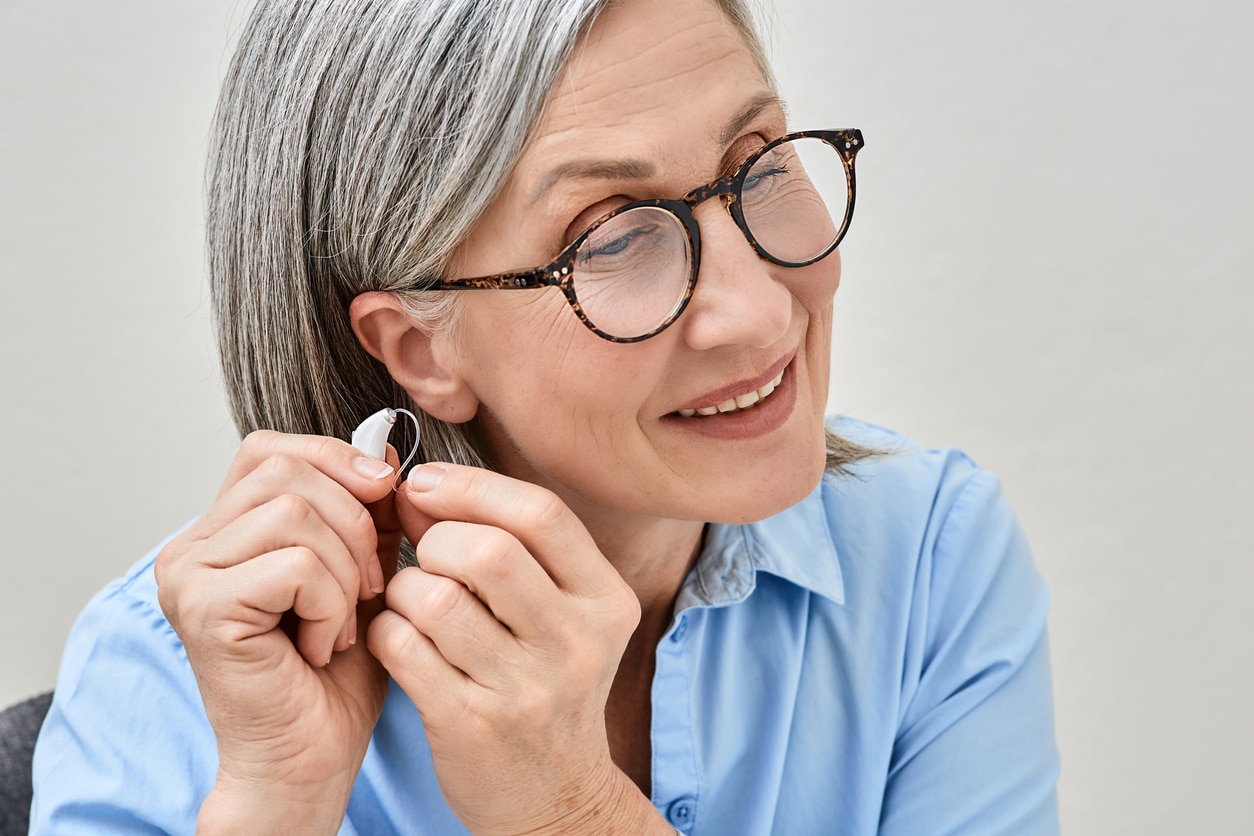 Woman putting on her new hearing aid