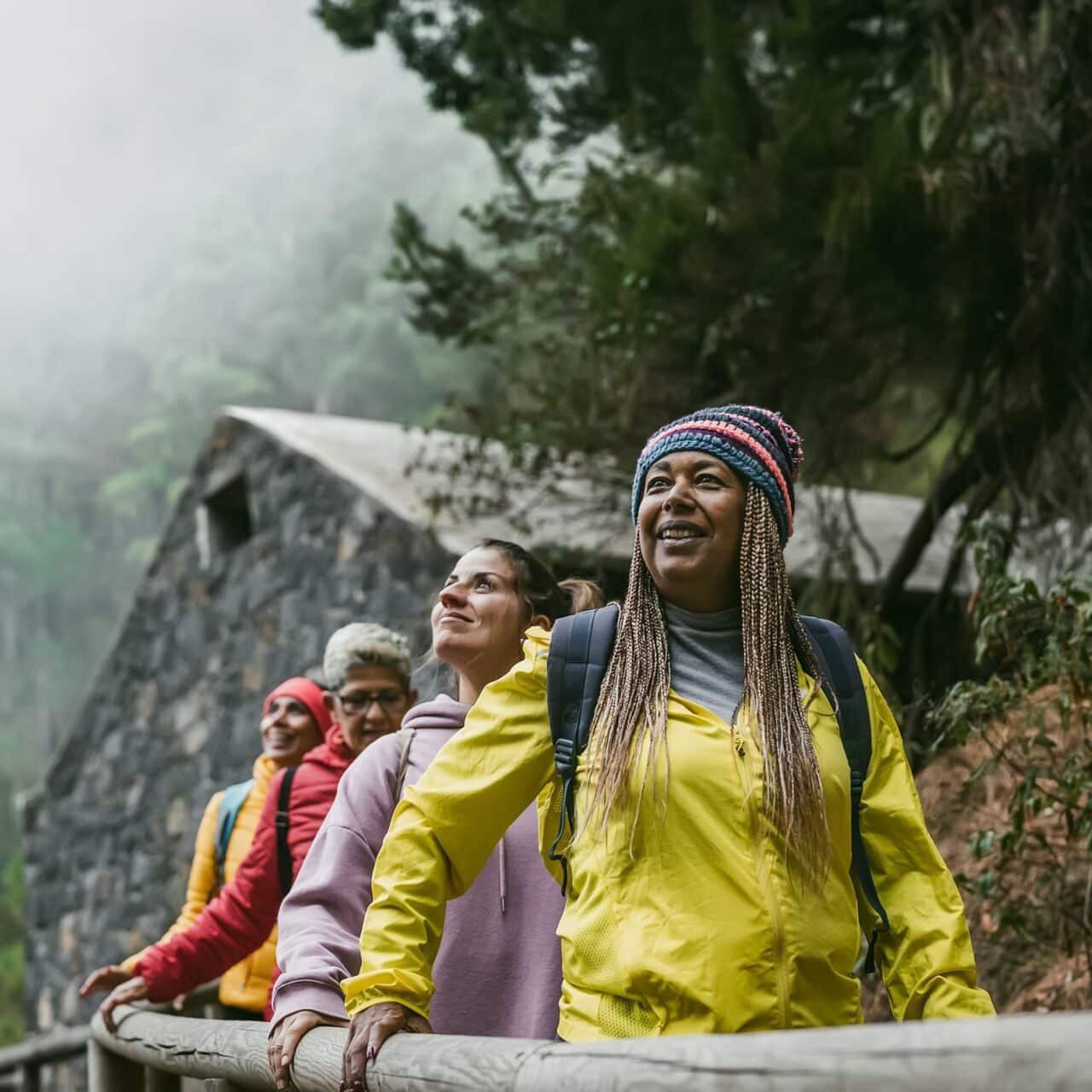 Group of friends hiking in a rainy forest.