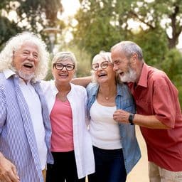 Four happy senior friends enjoying a joyful conversation outdoors